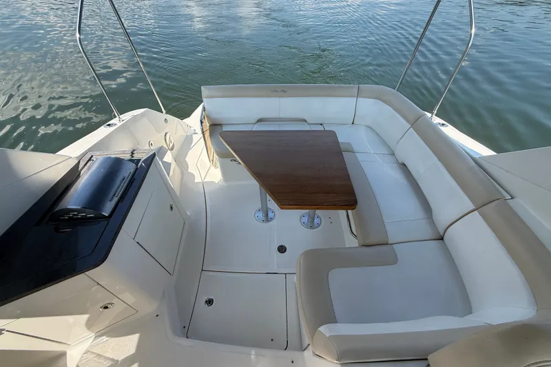 Slide: The Image of 2013 Sea Ray Sundancer 350 boat interior with white seating and wooden table. - 15