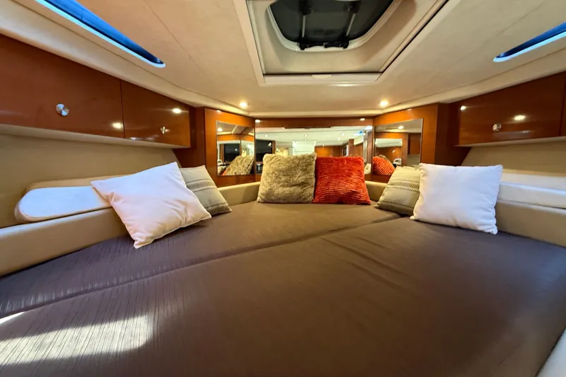 Slide: The Image of Luxurious cabin interior of 2013 Sea Ray Sundancer 350 with plush bedding and ambient lighting. - 40