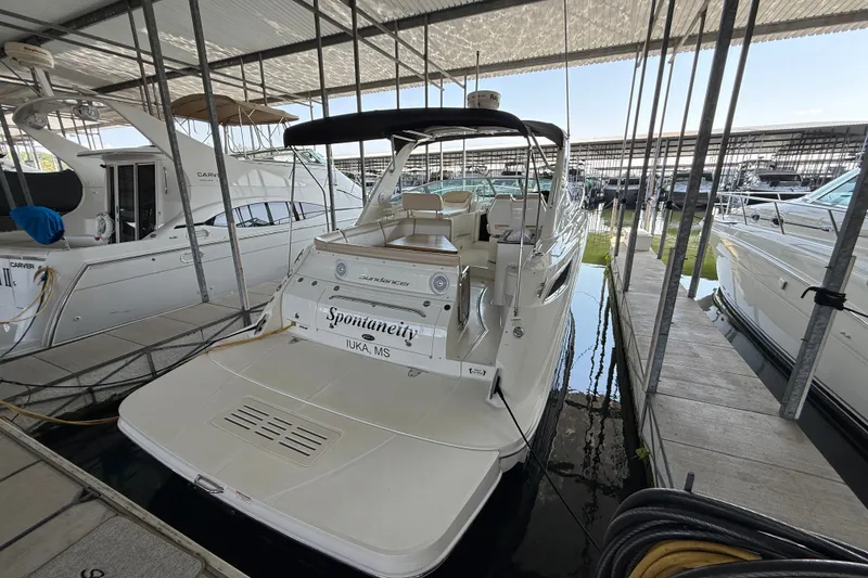 Slide: The Image of 2013 Sea Ray Sundancer 350 docked in a marina, showcasing sleek design and spacious deck. - 13