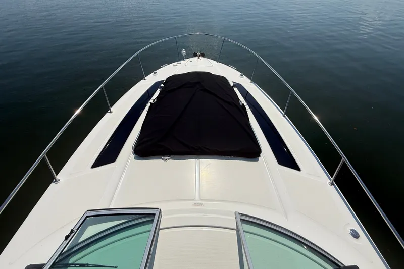 Slide: The Image of 2013 Sea Ray Sundancer 350 boat deck with black cover on calm water. - 18