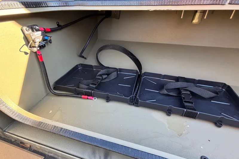 Slide: The Image of 2027 Tracker Grizzly 1756 T Marsh storage compartment with battery tray and wiring. - 14