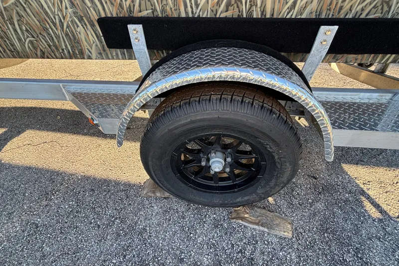 Slide: The Image of Trailer wheel of 2027 Tracker Grizzly 1756 T Marsh on asphalt surface. - 21