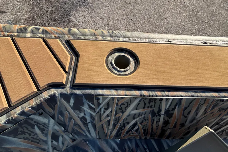 Slide: The Image of 2027 Tracker Grizzly 1756 T Marsh boat deck with camouflage pattern and rod holder. - 18