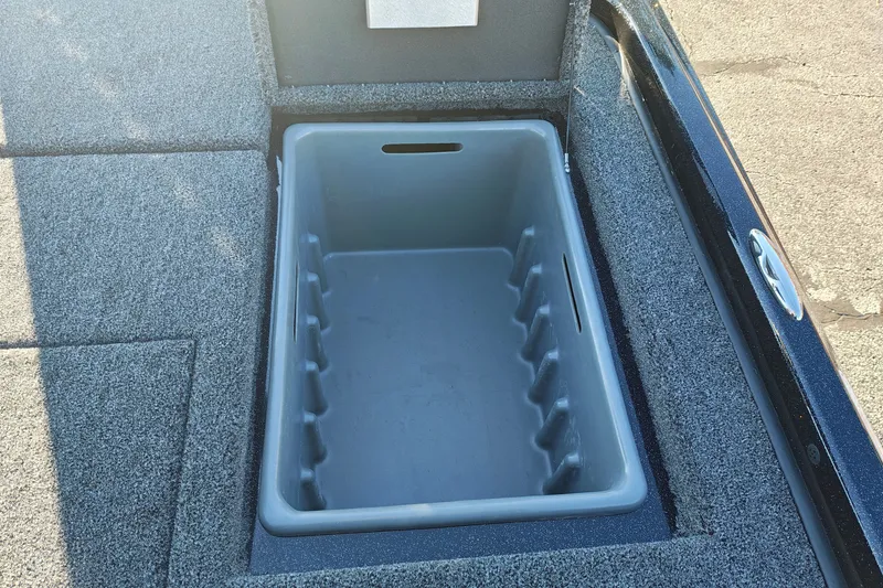 Slide: The Image of 2027 Nitro Z21 XL Pro boat storage compartment with gray interior and carpeted edges. - 41