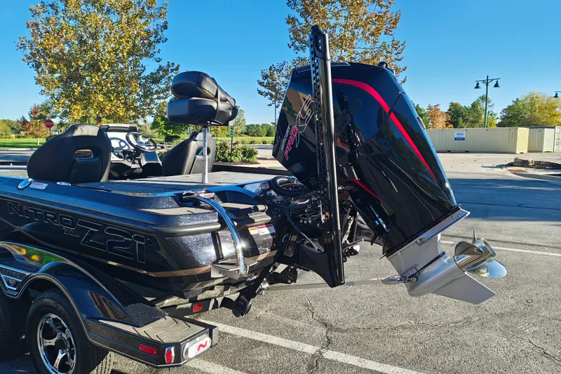 Slide: The Image of 2027 Nitro Z21 XL Pro boat with powerful outboard motor in a sunny parking lot. - 8