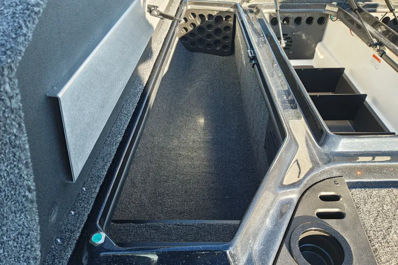 Slide: The Image of 2027 Nitro Z21 XL Pro boat storage compartment with organized rod holders and carpeted interior. - 27