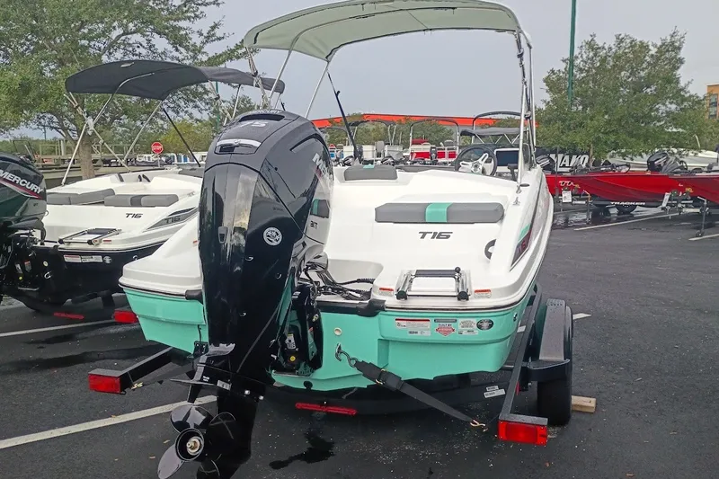 Slide: The Image of 2027 Tahoe T16 boat with outboard motor, parked on a trailer in a lot. - 3