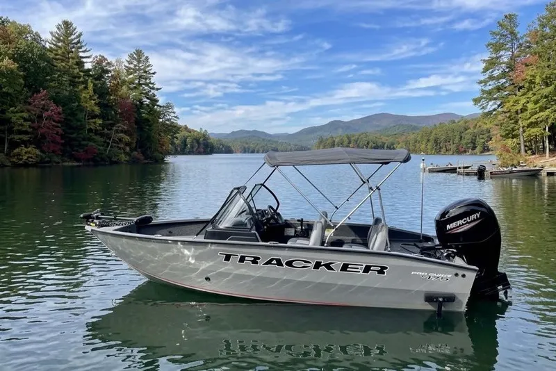 The Image of 2027 Tracker Pro Guide V-175 WT boat on scenic lake with forested shoreline. - 10