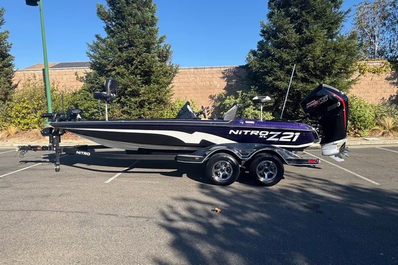Slide: The Image of 2027 Nitro Z21 XL Pro boat in parking lot, side view with trailer and motor. - 1