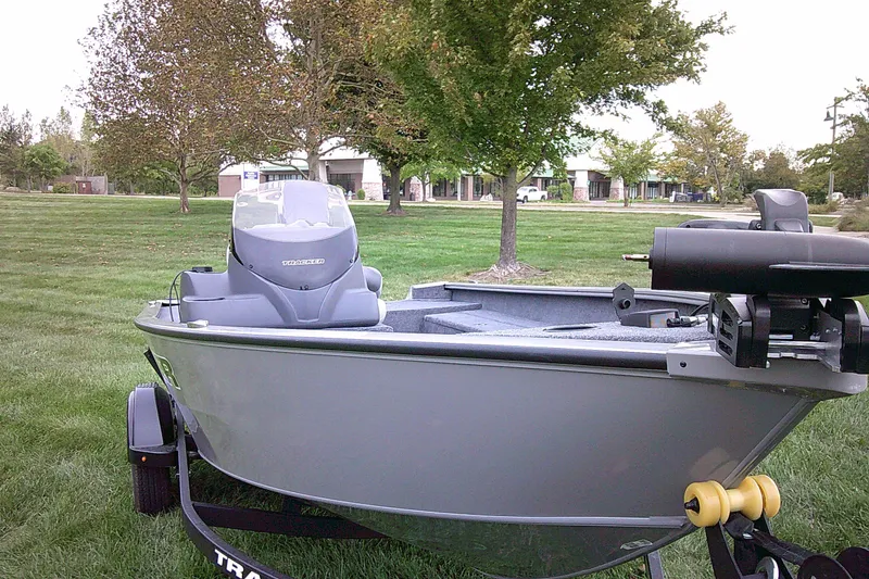 The Image of 2027 Tracker Super Guide V-16 SC boat on trailer in grassy park setting. - 0