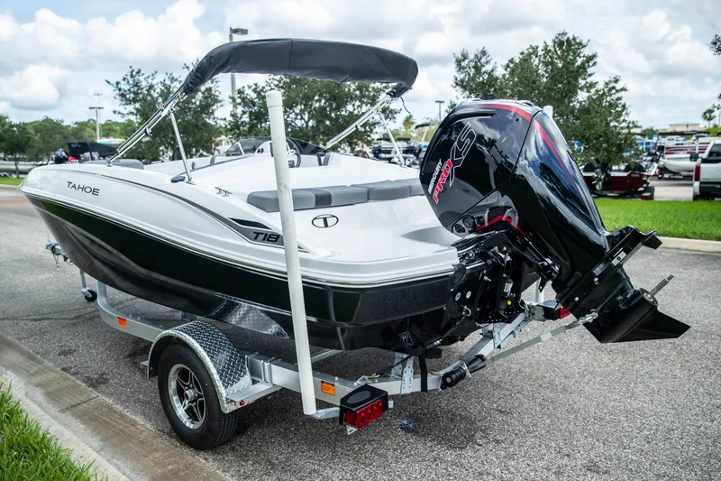 Slide: The Image of 2027 Tahoe T18 boat on trailer with powerful outboard motor, parked outdoors. - 6