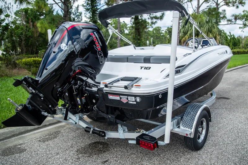 Slide: The Image of 2027 Tahoe T18 boat on trailer with powerful outboard motor, parked on roadside. - 7