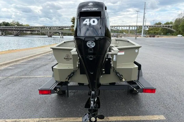 Slide: The Image of 2027 Tracker Grizzly 1553 Timber boat with Mercury 40 engine, parked near a river. - 18