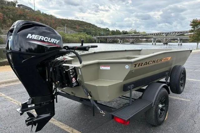 Slide: The Image of 2027 Tracker Grizzly 1553 Timber boat with Mercury engine, parked near a scenic river. - 23