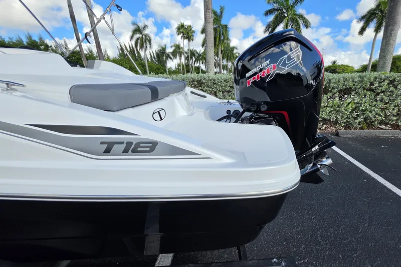 Slide: The Image of 2027 Tahoe T18 boat with Mercury Pro XS engine, parked outdoors under palm trees. - 13