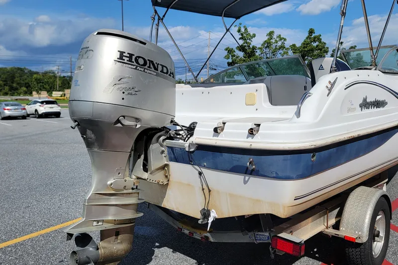 Slide: The Image of 2001 Hurricane SunDeck 217 OB boat with Honda outboard motor on a trailer. - 3