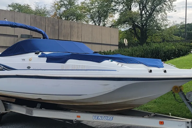 Slide: The Image of 2001 Hurricane SunDeck 217 OB boat on trailer, covered with blue tarp. - 21