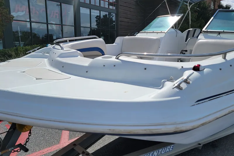 Slide: The Image of 2001 Hurricane SunDeck 217 OB boat on trailer, parked outdoors near a building. - 6