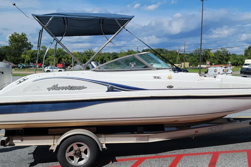 Slide: The Image of 2001 Hurricane SunDeck 217 OB boat on trailer, parked outdoors under blue sky. - 2