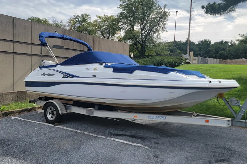 Slide: The Image of 2001 Hurricane SunDeck 217 OB boat on trailer, covered with blue tarp. - 22
