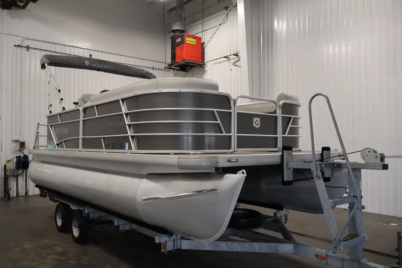Slide: The Image of 2021 Sweetwater 2086C pontoon boat on trailer in indoor storage facility. - 2