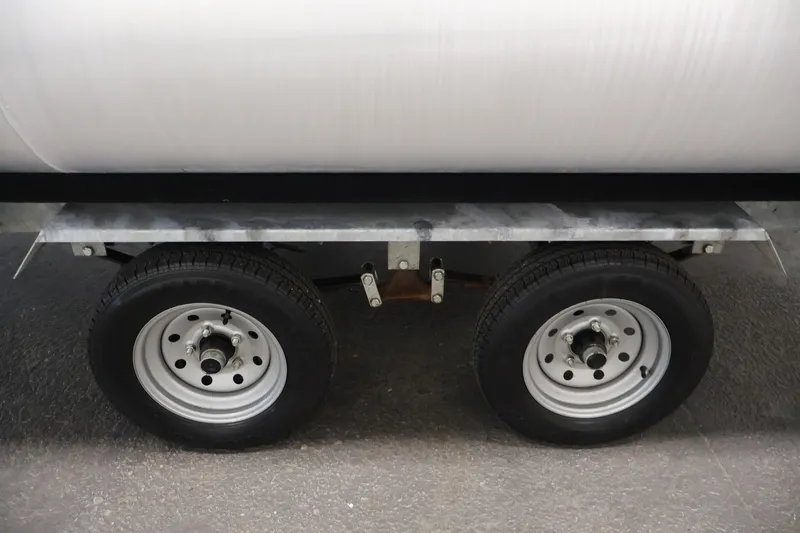 Slide: The Image of Trailer wheels of a 2021 Sweetwater 2086C, featuring dual tires on a concrete surface. - 39