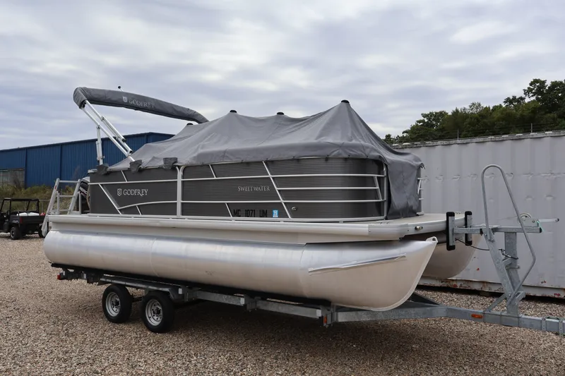 Slide: The Image of 2021 Sweetwater 2086C pontoon boat on trailer, covered and parked outdoors. - 40