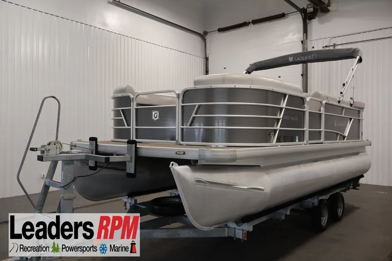 The Image of 2021 Sweetwater 2086C pontoon boat on trailer in indoor showroom. - 0