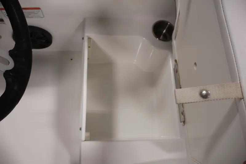 Slide: The Image of 2022 Tahoe T18 boat interior storage compartment with steering wheel detail. - 26