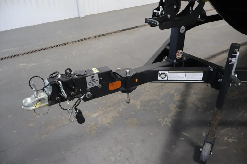 Slide: The Image of Trailer hitch of a 2022 Tahoe T18 boat, featuring safety chains and a jack stand. - 38