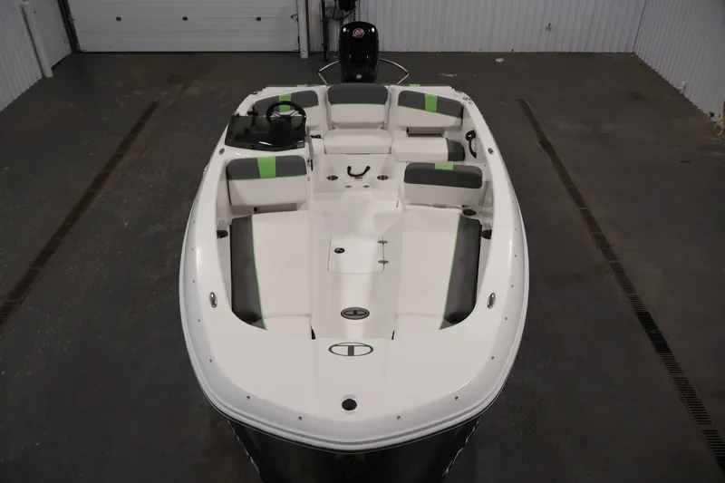 Slide: The Image of 2022 Tahoe T18 boat interior with white and green seating in a garage setting. - 8