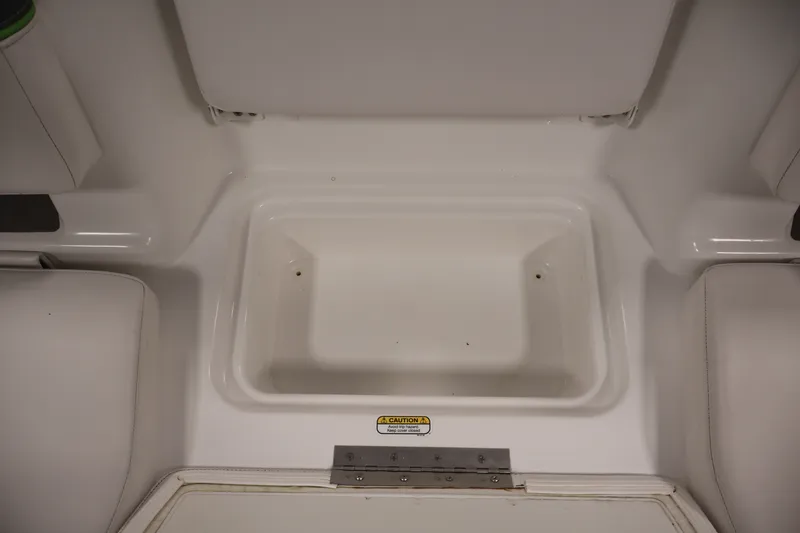 Slide: The Image of 2022 Tahoe T18 boat interior storage compartment, white finish, with caution label. - 24