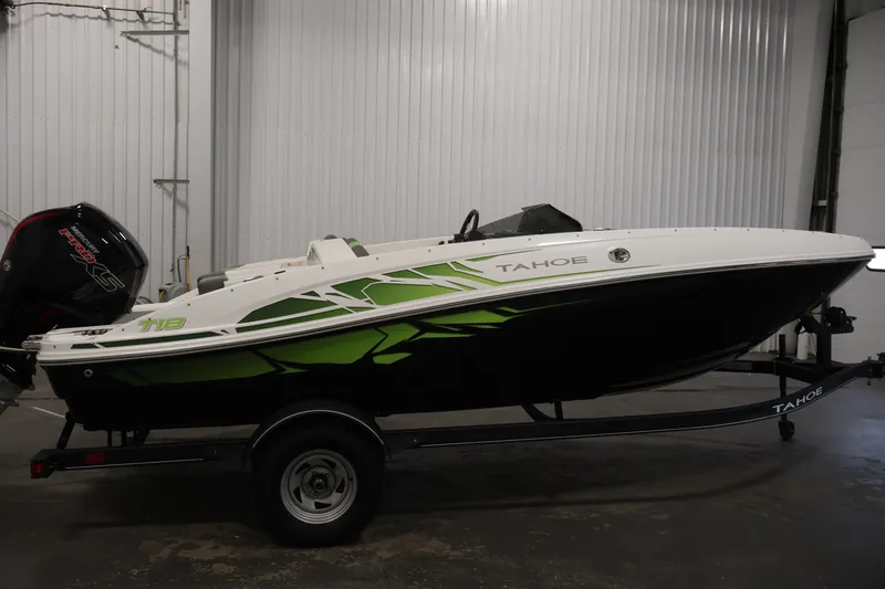 Slide: The Image of 2022 Tahoe T18 boat with green accents on a trailer in a garage. - 3
