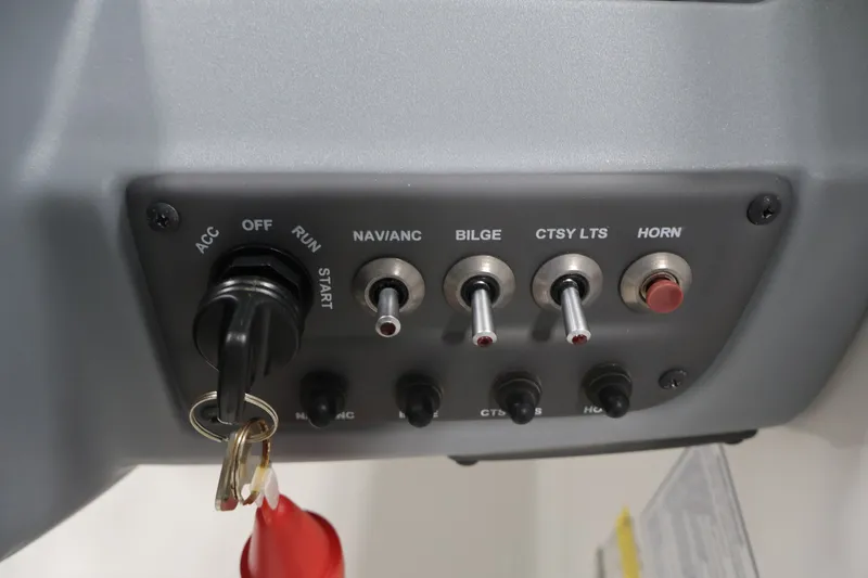 Slide: The Image of Control panel of a 2022 Tahoe T18 boat with switches and ignition key. - 18