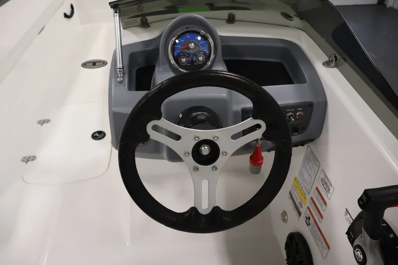 Slide: The Image of Steering wheel and dashboard of 2022 Tahoe T18 boat, featuring gauges and controls. - 14
