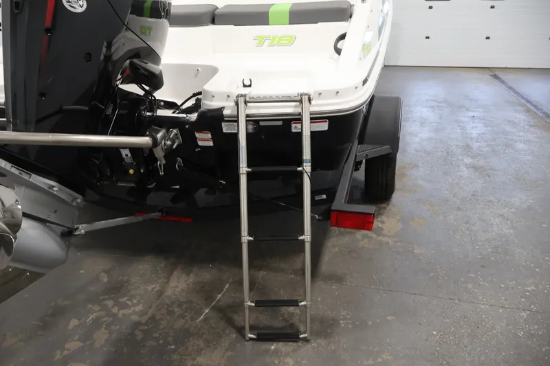 Slide: The Image of 2022 Tahoe T18 boat rear view with ladder and motor in a garage. - 33