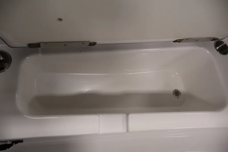 Slide: The Image of 2022 Tahoe T18 boat storage compartment with drain, open lid view. - 12