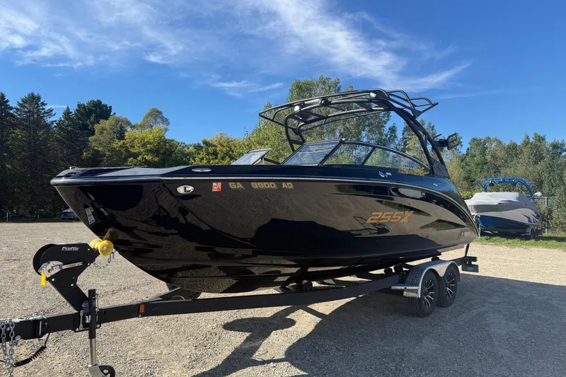 The Image of 2026 Yamaha Boats 255XD on trailer, sleek black design, parked outdoors. - 8