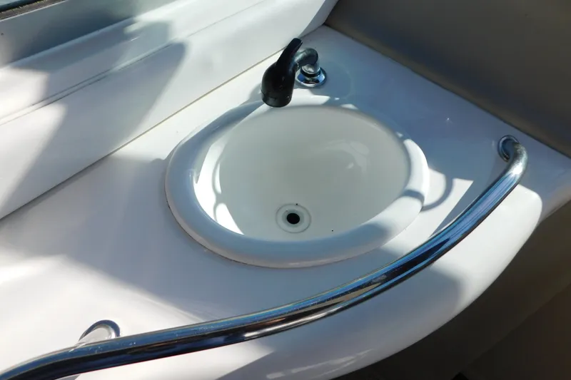 Slide: The Image of White sink with chrome faucet and rail on 2001 Sea Ray 300 Sundancer boat. - 25