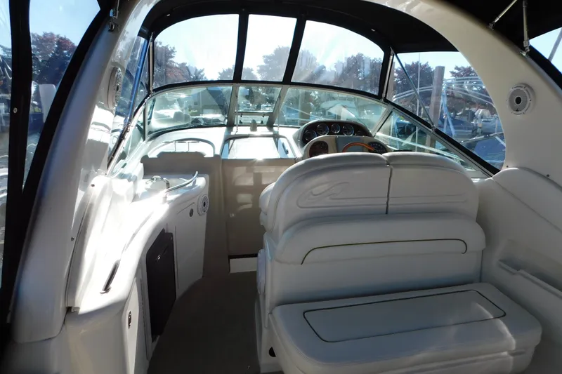 Slide: The Image of Interior view of a 2001 Sea Ray 300 Sundancer boat with white seating and dashboard. - 17
