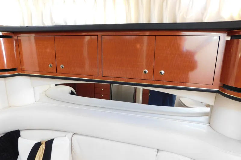 Slide: The Image of Interior of 2001 Sea Ray 300 Sundancer with wooden cabinets and white seating. - 63