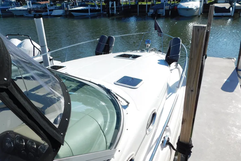 Slide: The Image of 2001 Sea Ray 300 Sundancer docked at marina, showcasing sleek design and spacious deck. - 5