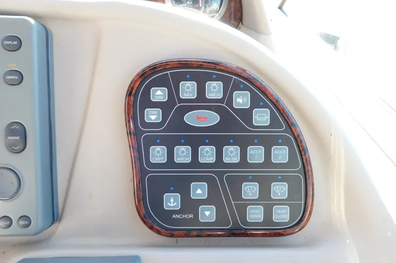 Slide: The Image of Control panel of a 2001 Sea Ray 300 Sundancer boat with various function buttons. - 32