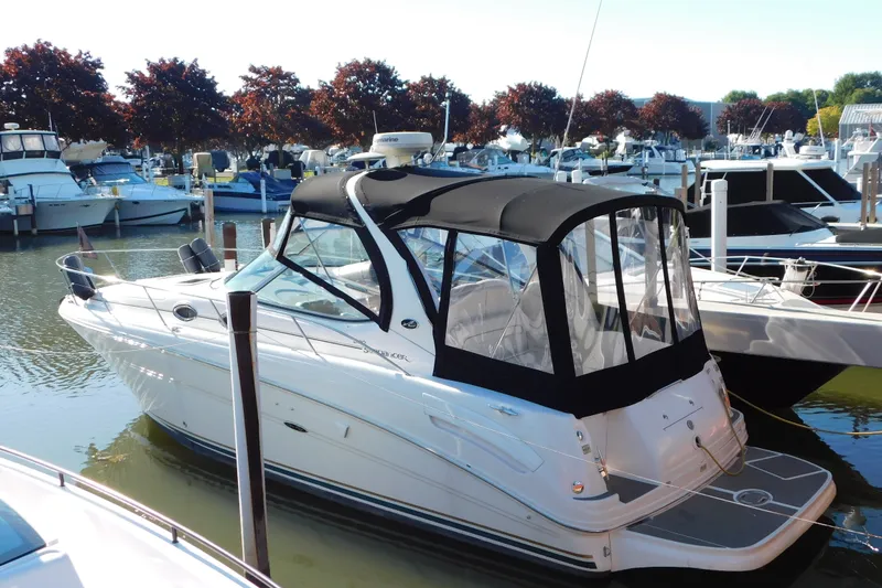 The Image of 2001 Sea Ray 300 Sundancer boat docked at marina with black canopy. - 1