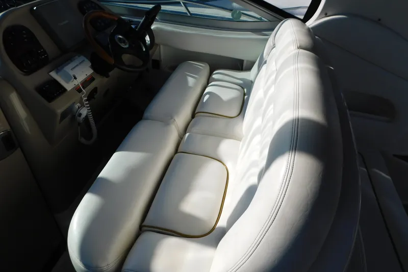 Slide: The Image of Interior of 2001 Sea Ray 300 Sundancer with white leather seating and steering console. - 28