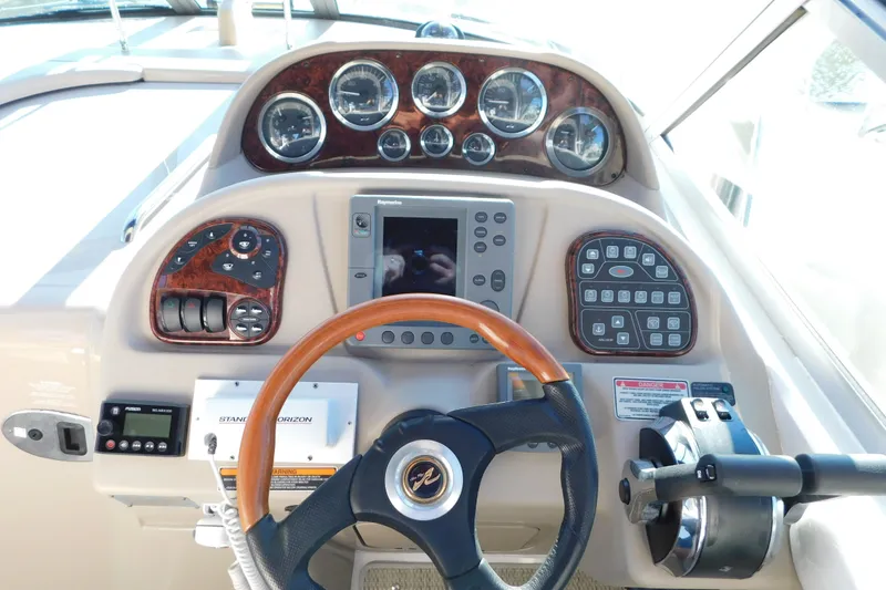 Slide: The Image of Control panel of a 2001 Sea Ray 300 Sundancer boat with gauges and steering wheel. - 29