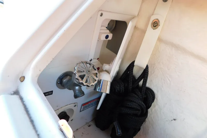 Slide: The Image of 2001 Sea Ray 300 Sundancer boat faucet and coiled rope in storage compartment. - 14