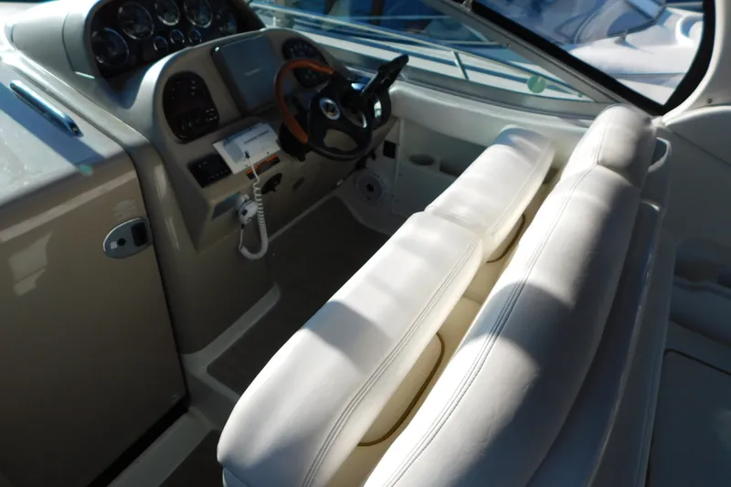 Slide: The Image of Interior of 2001 Sea Ray 300 Sundancer boat with steering wheel and white seating. - 27