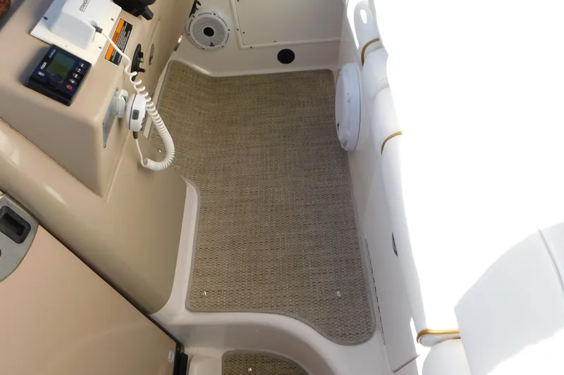 Slide: The Image of Interior view of a 2001 Sea Ray 300 Sundancer boat cockpit with beige flooring. - 80
