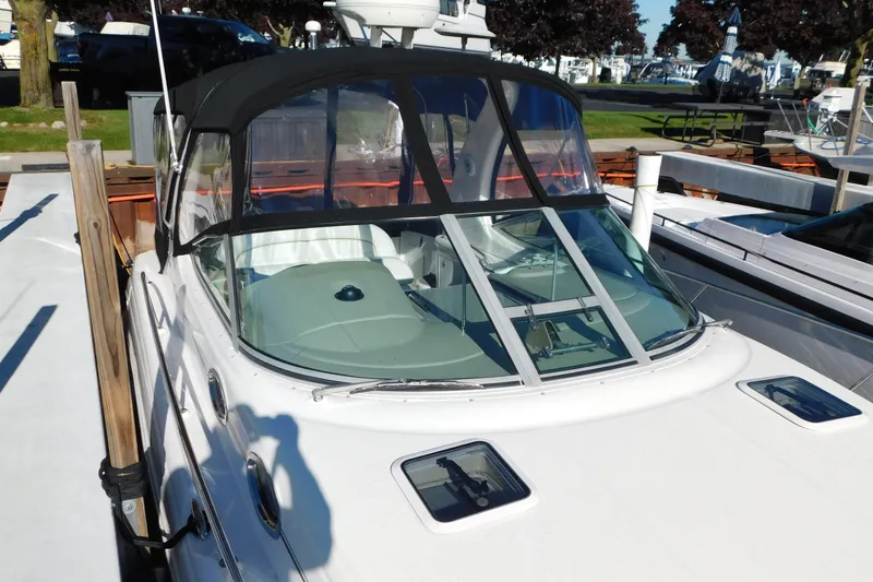 Slide: The Image of 2001 Sea Ray 300 Sundancer docked, featuring a sleek design and black canopy. - 7